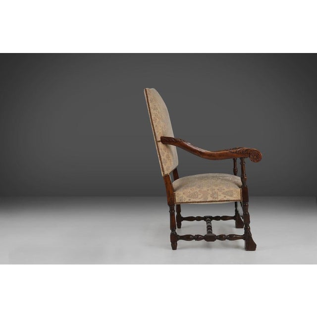 This 19th-century magnificent throne chair is made of oak wood and upholstered in fabric with an ornate motif. The wood is...