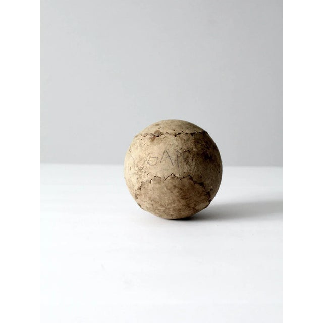This is an antique softball. The large leather softball is likely from the early years of the game. Beautiful wear to the...