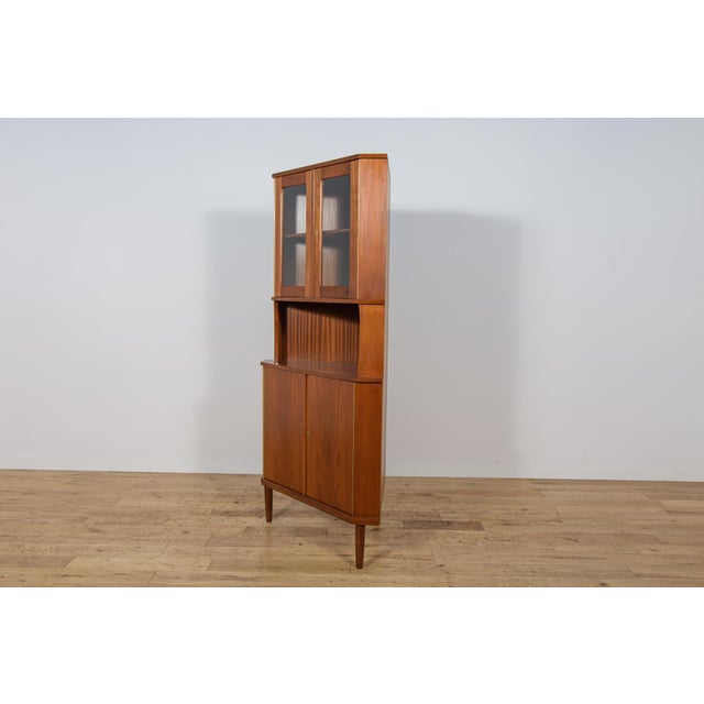 This teak corner cabinet was manufactured in Denmark during the 1960s. It is an excellent example of Scandinavian Mid-...