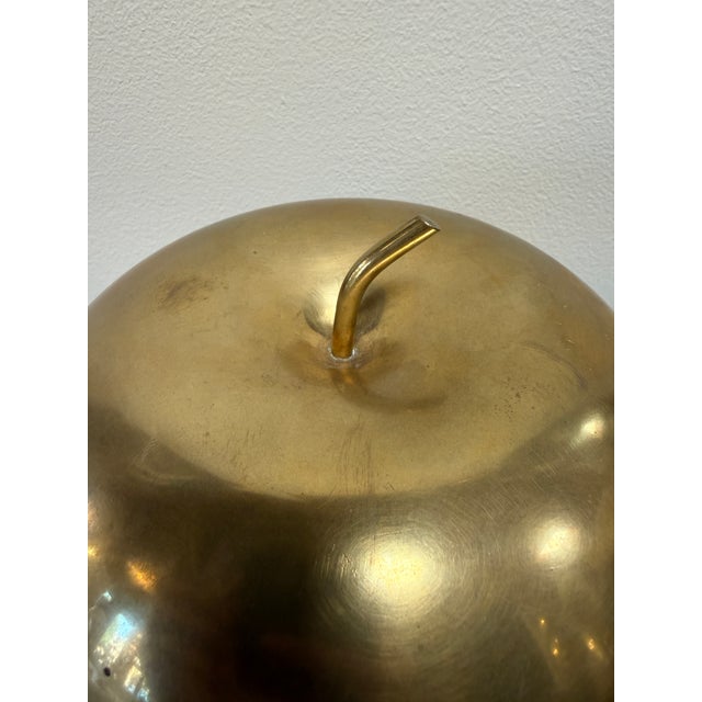 A sculptural mid-century Italian bowl designed in the form of an apple, crafted entirely in warm-toned brass. The piece...