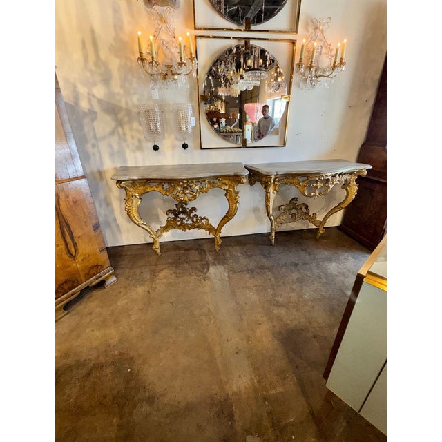 The product is a pair of 19th century French Louis XV giltwood consoles, which are ornate and elegant tables commonly used...