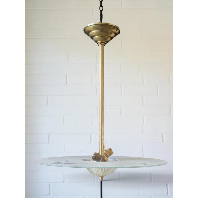 Art Deco pendant light in gilded metal with a glass disc. In good condition with normal signs of wear. Shipped via...