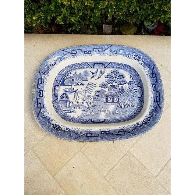 Very old blue Willow platter with a small chip and old plate hanger.. very worn back and edges.