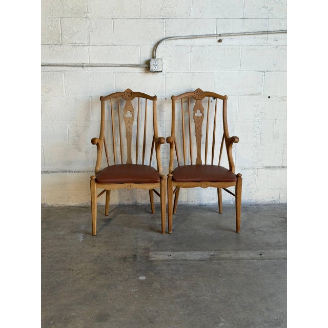 This vintage set of 2 armchairs features an elegant high-back silhouette with subtly curved armrests and contoured back...