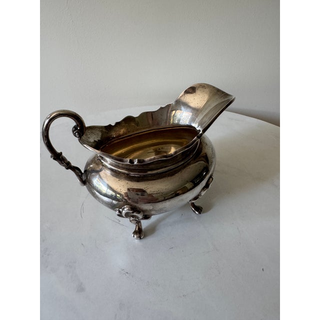 A distinguished antique Edwardian sterling silver sauce boat, hallmarked at the Glasgow Assay Office and bearing British...