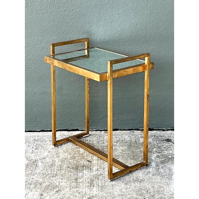 Crafted with clean geometric lines, this vintage mid-century side table features a slender brass frame paired with an...