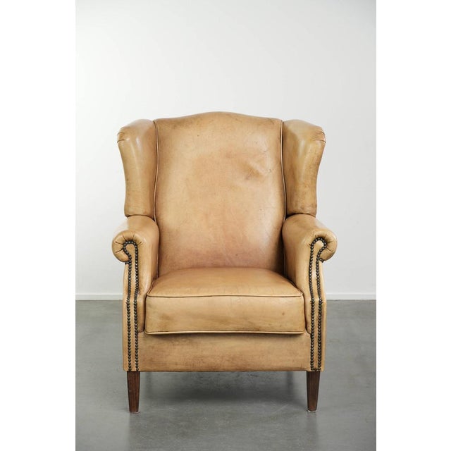 This beautiful light cowhide wing armchair has a timeless English look and good seating comfort. It features a fixed seat...