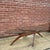 A striking coffee table designed by Forest Wilson, featuring his signature sculptural walnut base beneath a large oval...