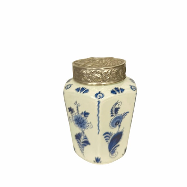 Vintage Delft blue snd white six sided tea caddy with pressed silver metal lid. The lid is pressed with a fruit pattern....