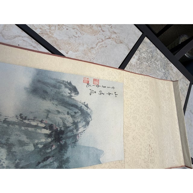 Elegant vintage Chinese hanging scroll depicting a dramatic traditional mountain landscape rendered in atmospheric blue-...