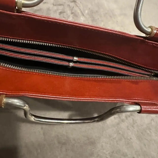 An exquisite 1970s Italian shoulder bag, a timeless piece of vintage luxury. Crafted from supple, high-quality red...