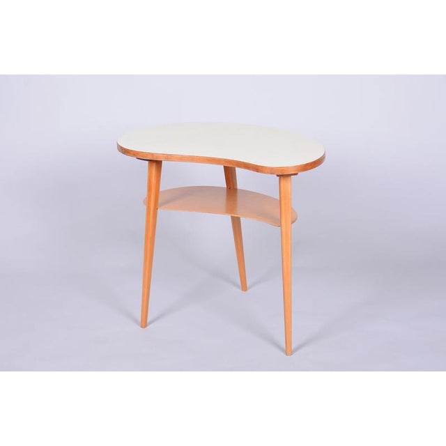 This elegant side table dates back to the 1950s and represents an iconic example of Czechoslovak "Mid-Century" design. The...