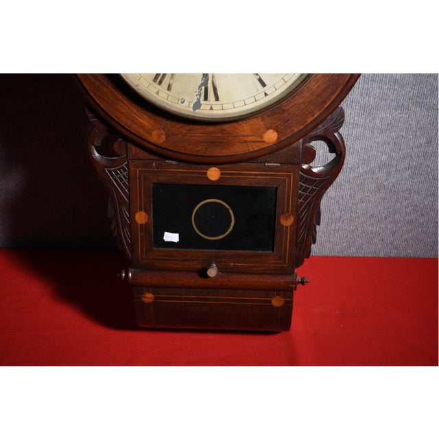 A 19th century inlaid Rosewood drop dial wall clock with decorative inlay around the bezel, shaped ears and trunk,...