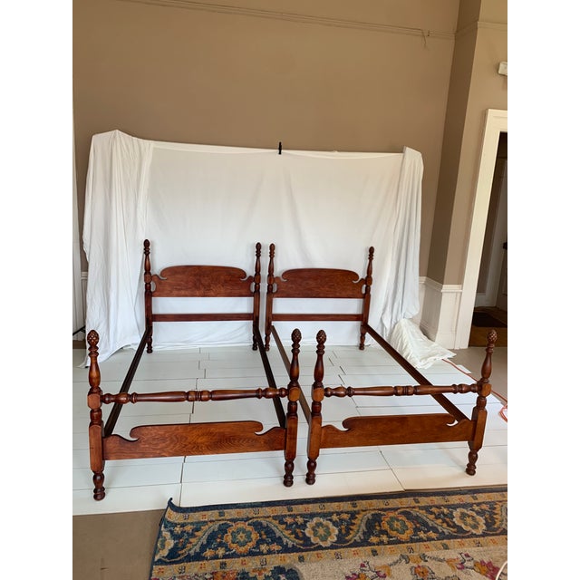 Beautiful pair of vintage pine pineapple post beds featuring classic turned posts and distinctive pineapple finials. The...