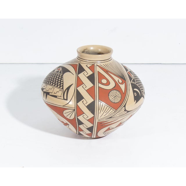 A Mata Ortiz pottery vase by the Mexican artist Cesar Dominguez. This vase features a rounded shape and an intricate,...