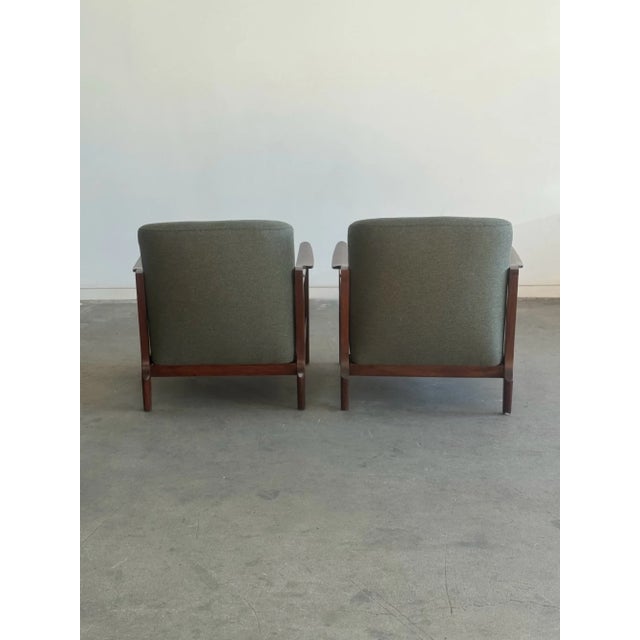 W29 D28 H30 SW24 SD18.5 SH15 AH21 This pair of restored mid century lounge chairs defined by its sculptural walnut frames...