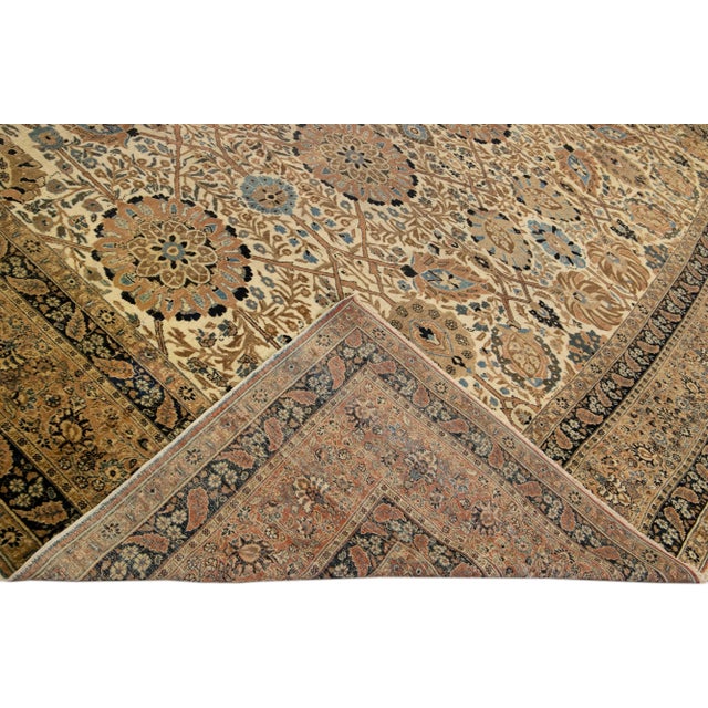 Beautiful antique Persian Tabriz hand-knotted wool rug with a beige field. This piece has a designed frame and a gorgeous...