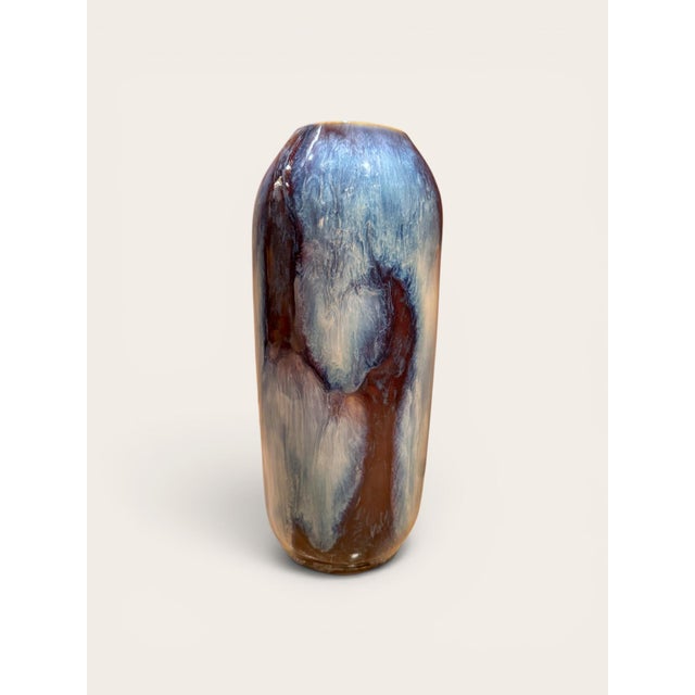 A glazed ceramic vase by Gene Farkus, designed with a tall rounded cylindrical form and narrow opening. The piece features...