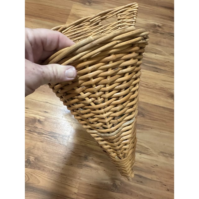 This is a pair of cone-shaped wicker wall pockets. • Material: They are crafted from natural wicker, woven in a...