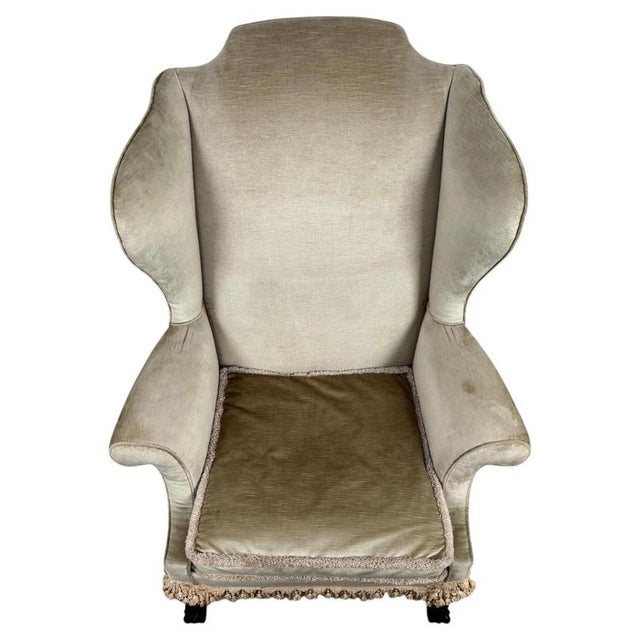 An elegant early 20th-century English wingback armchair, finely crafted with a mahogany frame and distinguished by its...