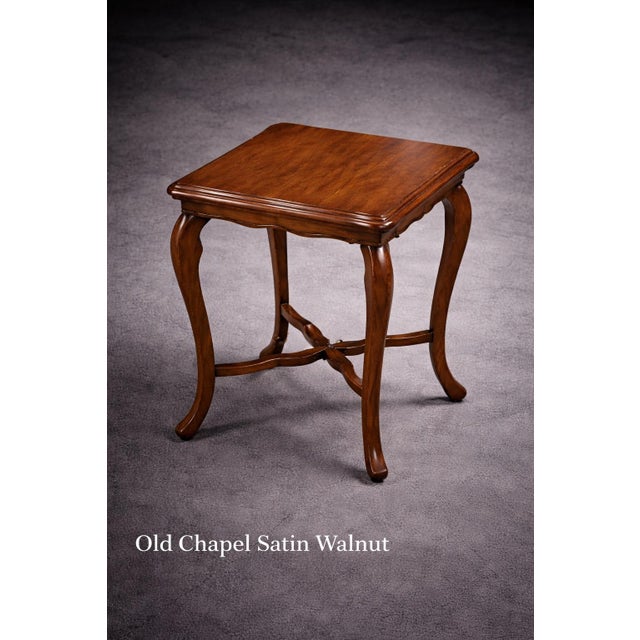 Elegant French Provincial side table with a scalloped square top and cabriole legs, finished in a warm walnut tone....