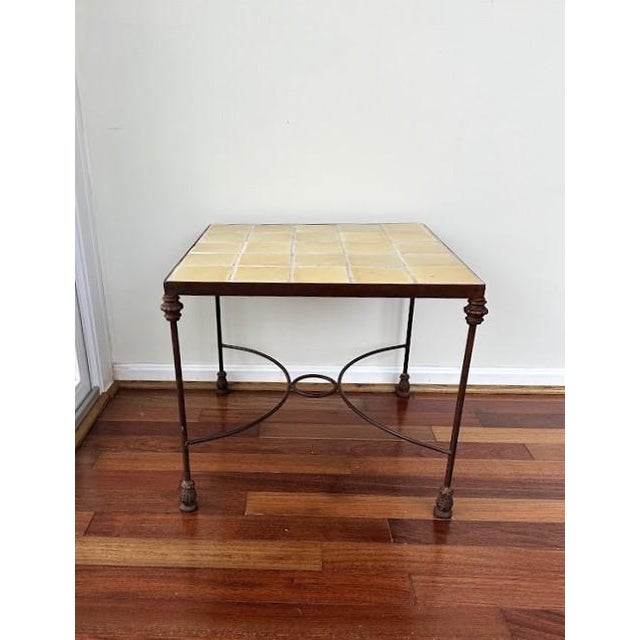 Vintage yellow tile-top side table. Dark wrought iron frame and curved stretcher base.