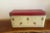 A beautifully sized vintage bread box featuring a soft cream base adorned with scattered floral accents and a bold red...