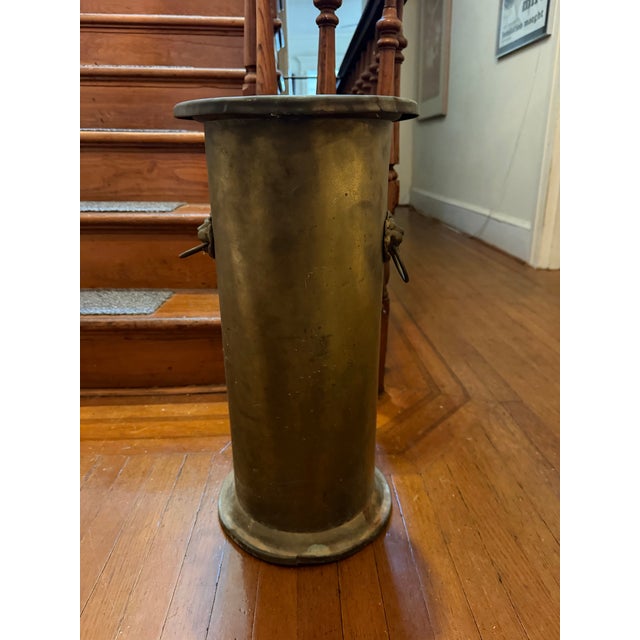 Antique brass umbrella stand with two lions head. H: 22” Diameter: 10.5”