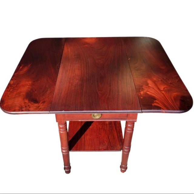 c.1830 Solid Mahogany Drop Leaf Table features rich warm hues of deep red mahogany with a striking amber glow flame grain...