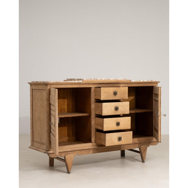 A distinguished example of French Art Deco craftsmanship, this circa 1940 sideboard is rendered in richly grained oak with...