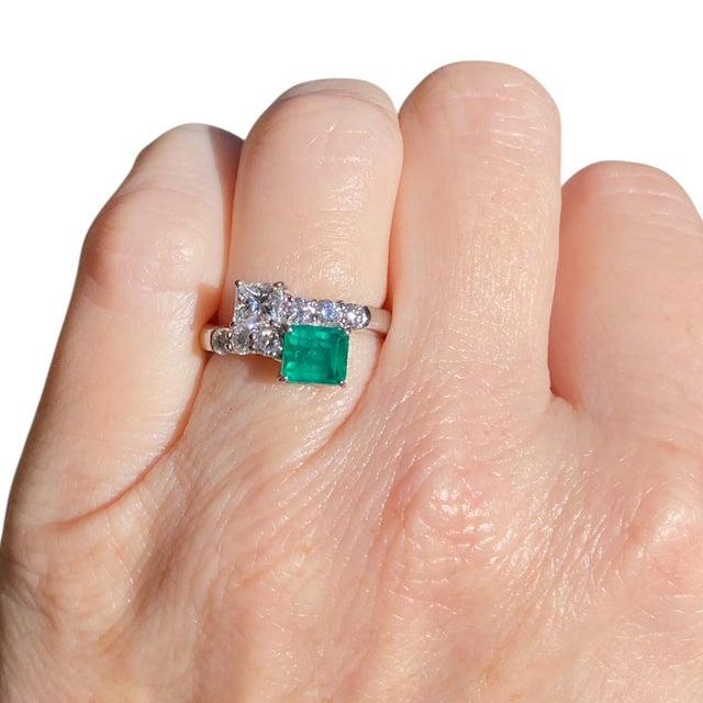 Platinum toi et moi style ring featuring a striking design with an deep green emerald and white diamonds. The emerald and...
