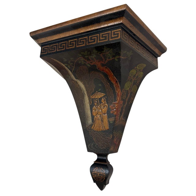 Pair of wood lacquered wall brackets. Black with raised sculptural design. Gilded accents, greek key banding. People in a...