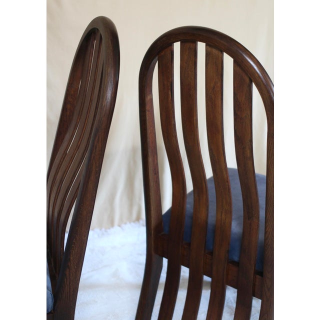 A set of 4 beautiful oak chairs in a dark stain and in excellent vintage condition. Arched top with vertical slats that...