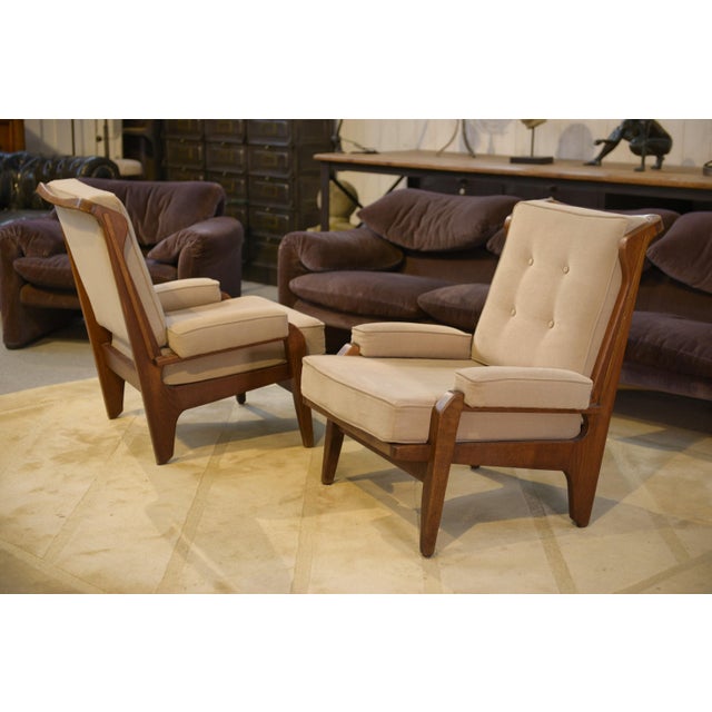 Pair of Guillerme & Chambron armchairs for “Votre Maison”, 1960s, with oak frames, slightly flared legs, and integrated...