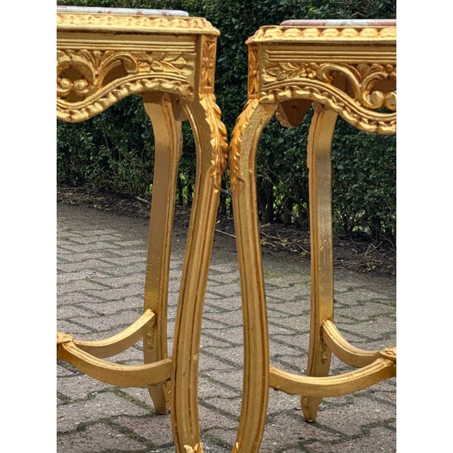 This elegant pair of circa 1980 French Louis XVI–style side tables combines finely carved solid beechwood frames with warm...