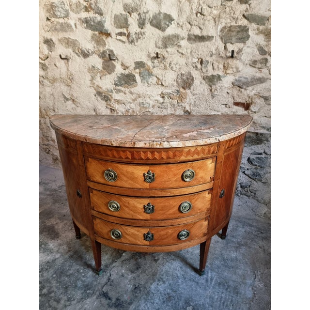 Elegant French demi-lune commode dating from the late 18th century, crafted in the refined Louis XVI style. Featuring a...