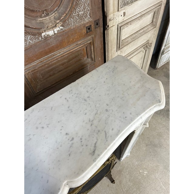 A louis xv style flat fireplace, circa 1900. The jambs and lintel have been recut, and the mantelpiece has a single-...