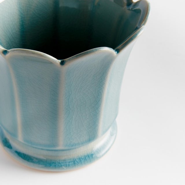 In a classic silhouette with petal shaped rim, this footed pot is natureinspired. Finished in a soft sage reactive glaze,...