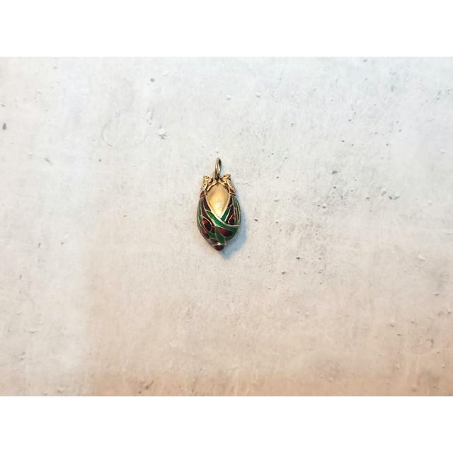 This exquisite vintage Chinese gilded silver egg pendant, adorned with stunning enamel and granulated accents, features...