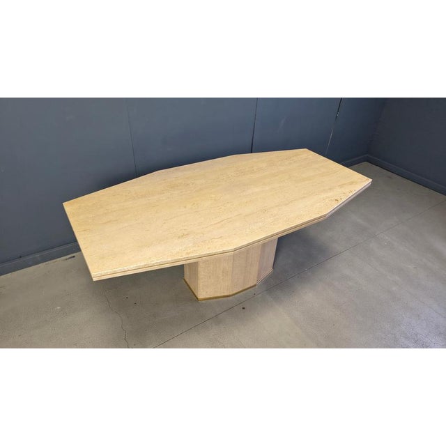Vintage solid travertine dining table. The table has a thick durable top and a single central travertine base. Brass...