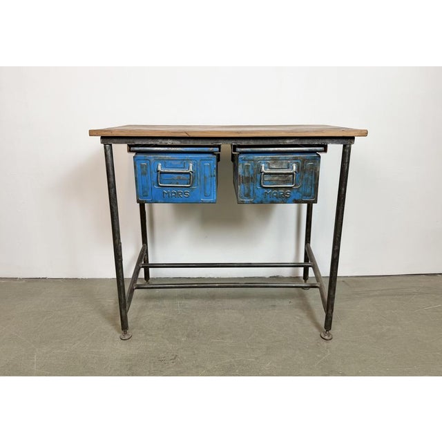 Vintage Industrial worktable from the 1960s. It features an iron construction, a solid wooden plate and two iron drawers....