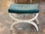 A well-proportioned curule stool on a painted X-frame base with a turned stretcher and carved rosette medallions at the...