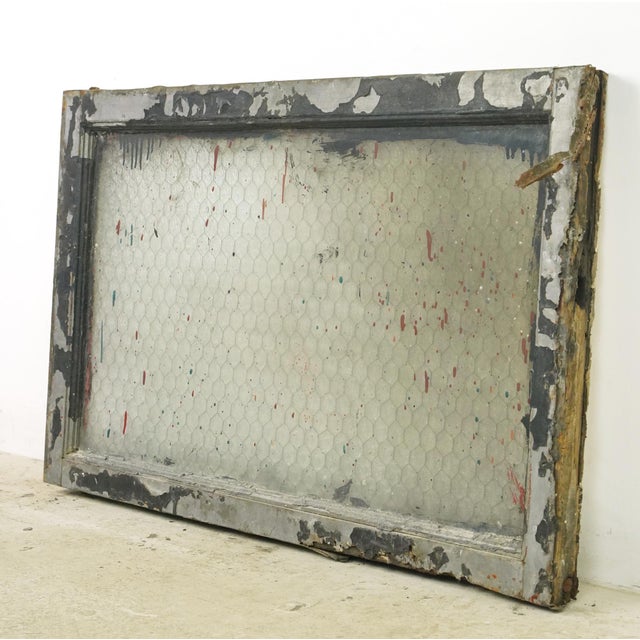 Reclaimed rectangular shaped window with a wood frame, steel sides, and a clear wormy chicken wire glass pane. It was...