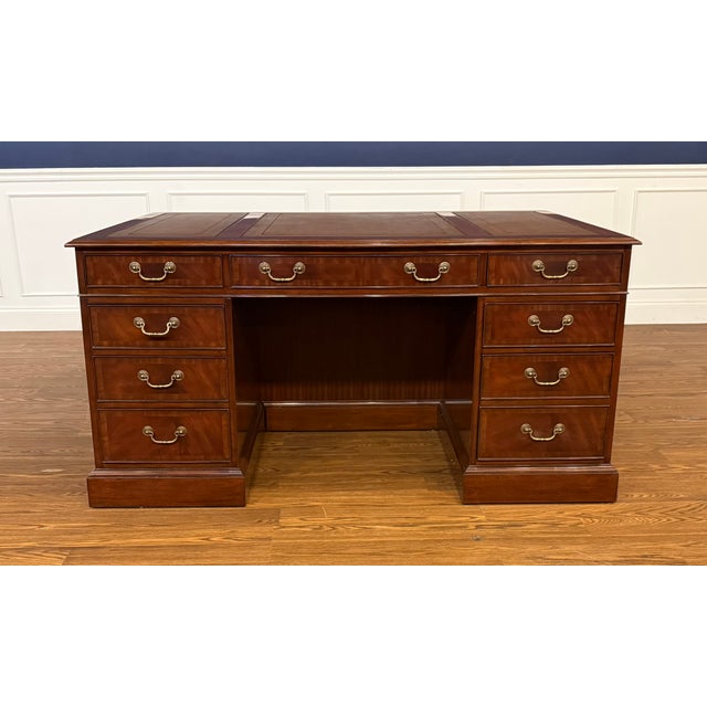 This is a traditional mahogany executive desk by Leighton Hall. It features front, side and drawer panels of swirly crotch...