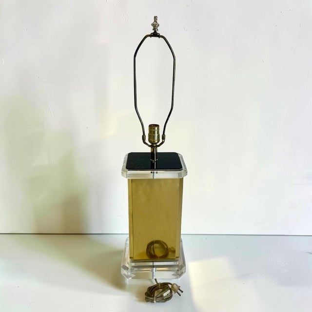 Vintage 1980s table lamp with thick lucite base and top, with brass sides. Very unique lamp, to add a touch of mid-century...