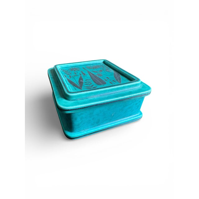 This stunning ceramic turquoise trinket or keepsake box has applied designs of flowers and leafs and was designed by...