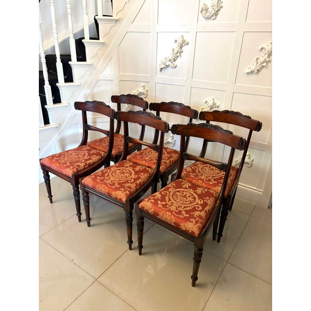 A fine set of six Regency rosewood dining chairs each displaying elegant flowing lines and refined carved detail. The...