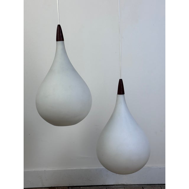 Two-light chandelier in wood and opaline glass by Uno & Osten Kristiansson for Luxus 1957, Sweden. Composed of two large...