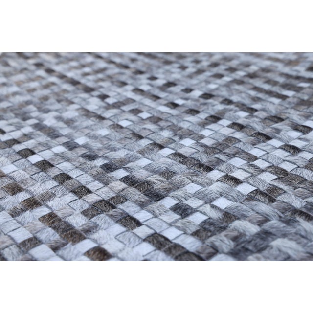 Introduce exceptional texture and artisan craftsmanship into your home with this 16 x 24 inch handcrafted woven cowhide...