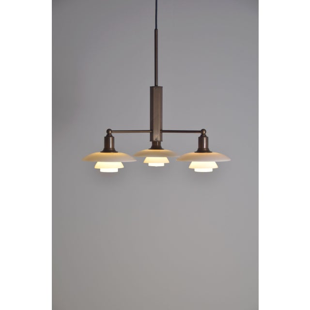 PH 2/1 chandelier designed by Poul Henningsen and manufactured by the renowned lamp manufacturer Louis Poulsen. This copy...